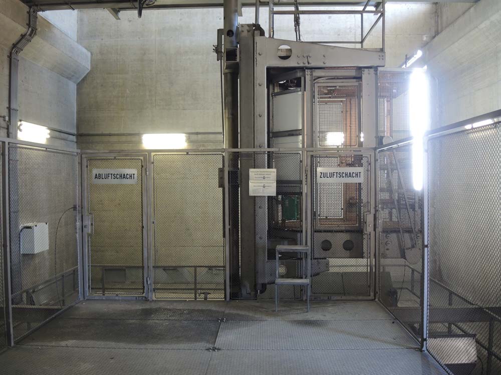 Industrial system with metal grilles and signage for exhaust and supply air ducts in a technical building with concrete walls